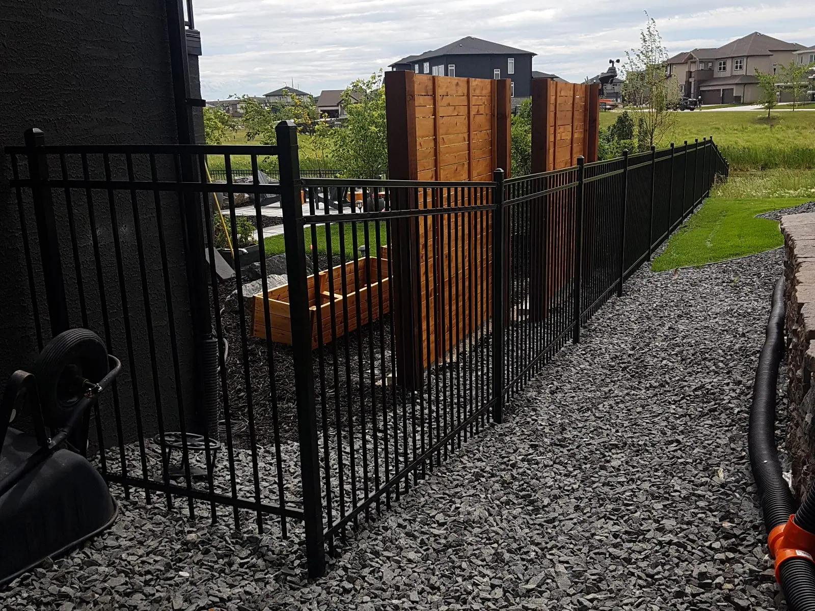 Black ornamental steel fence along a side yard